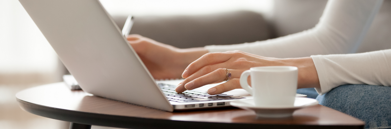 Close up woman using laptop, sitting on sofa, female hands typing, writing blogs, studying languages, working at home