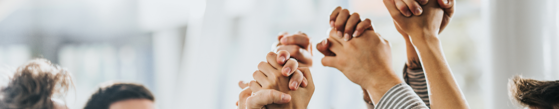 Large group of happy business colleagues holding their hands in unity.